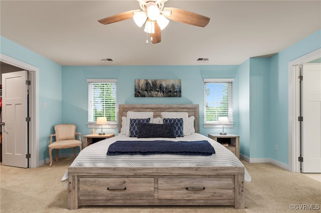 bedroom with baseboards, visible vents, and light carpet