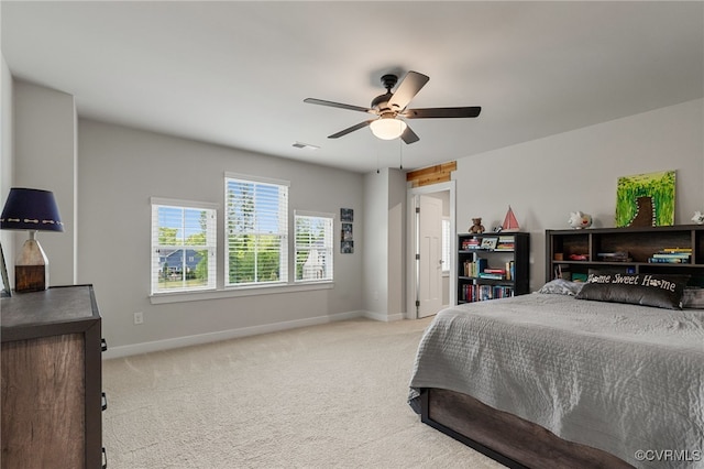 bedroom featuring a ceiling fan, baseboards, visible vents, and light carpet