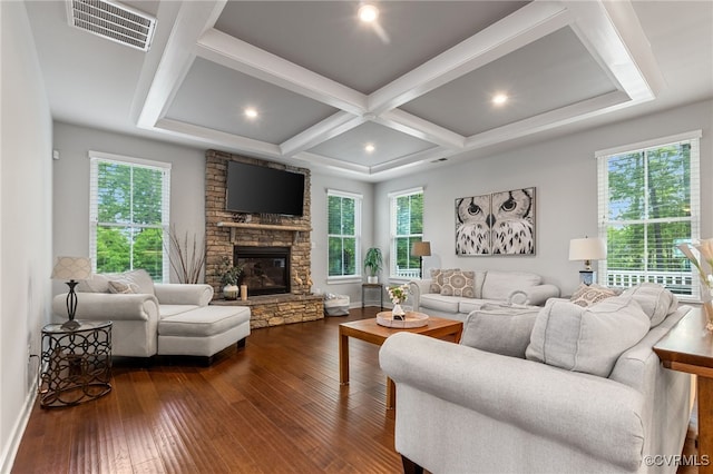 living area with dark wood-style flooring, a stone fireplace, visible vents, baseboards, and coffered ceiling