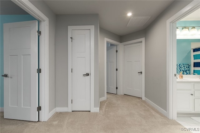 corridor with visible vents, carpet, and baseboards