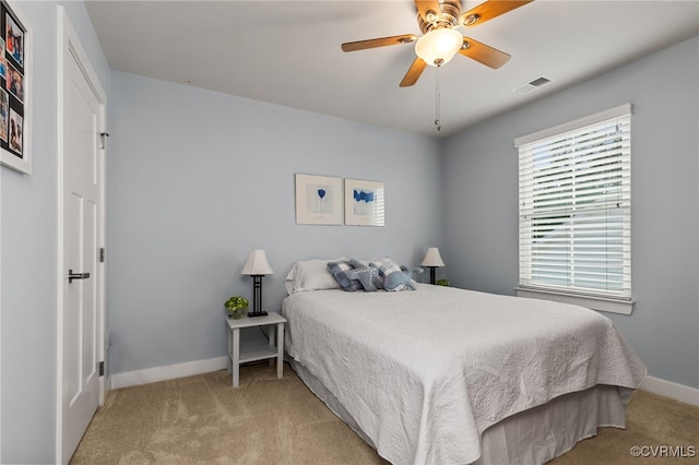 bedroom featuring a ceiling fan, baseboards, light colored carpet, and visible vents