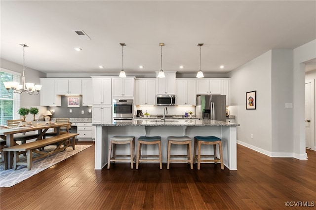 kitchen featuring an island with sink, stainless steel appliances, recessed lighting, white cabinetry, and decorative backsplash