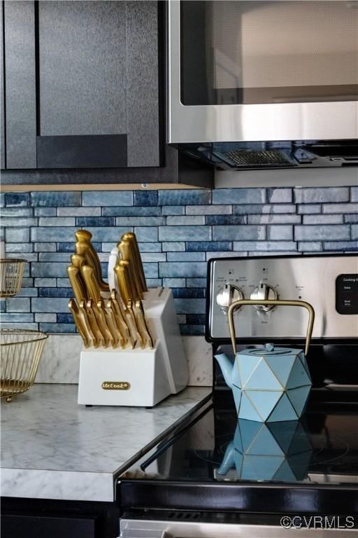 room details with stainless steel appliances and decorative backsplash