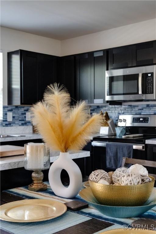 details with dark cabinets, appliances with stainless steel finishes, and backsplash