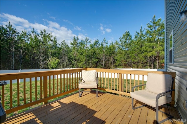 wooden deck with a yard and a wooded view