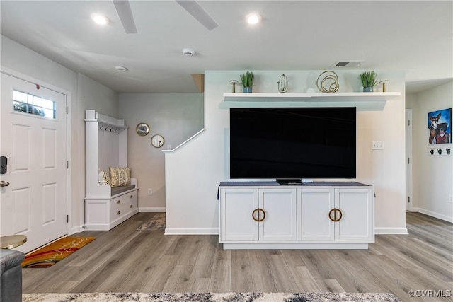living room with baseboards, visible vents, and light wood-type flooring