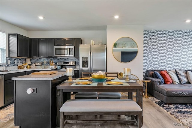 kitchen with light wood-style floors, light countertops, open floor plan, and stainless steel appliances