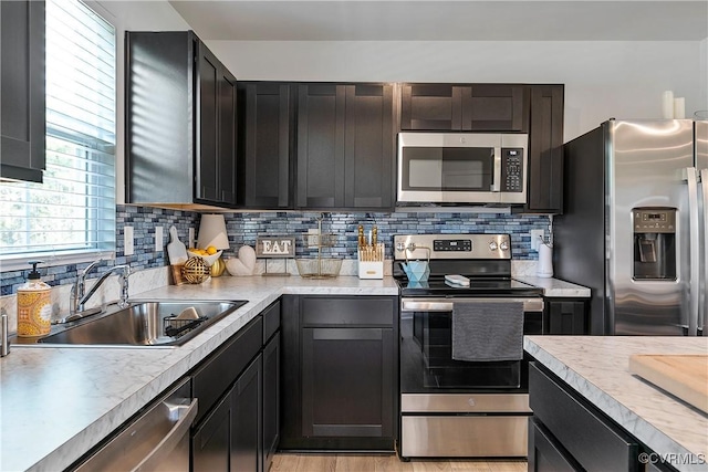 kitchen featuring a sink, light countertops, tasteful backsplash, and stainless steel appliances