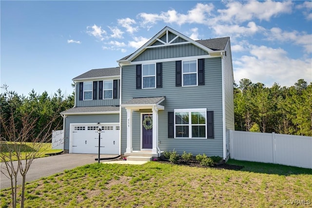traditional-style home featuring board and batten siding, a front yard, a garage, fence, and aphalt driveway