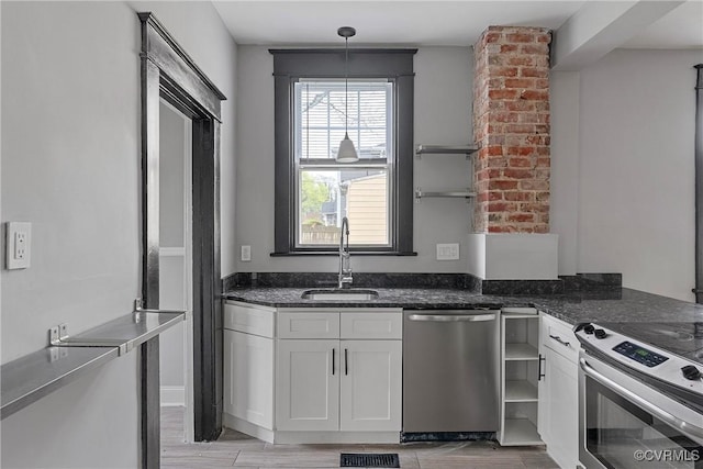kitchen featuring appliances with stainless steel finishes, open shelves, a sink, white cabinets, and dark stone counters