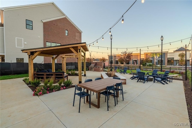 501 Golden Haze Aly Unit 16-1, Midlothian, VA 23113 - patio terrace at dusk with outdoor dining space, fence, and an outdoor fire pit