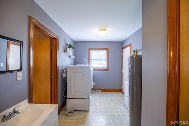 400 E California Ave, Crewe, VA 23930 - bathroom featuring vanity, gas water heater, tile patterned floors, washer / clothes dryer, and visible vents