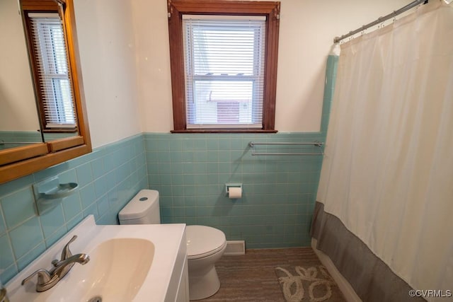 400 E California Ave, Crewe, VA 23930 - bathroom featuring vanity, wainscoting, curtained shower, toilet, and tile walls
