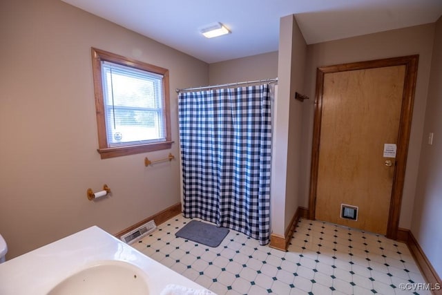 400 E California Ave, Crewe, VA 23930 - full bathroom featuring visible vents, baseboards, a shower with shower curtain, tile patterned floors, and a sink