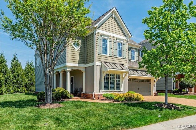 view of front of property featuring an attached garage, a front yard, a standing seam roof, driveway, and metal roof
