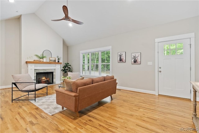 4482 Anderson Hwy, Powhatan, VA 23139 - living room featuring light wood finished floors, ceiling fan, a warm lit fireplace, high vaulted ceiling, and baseboards