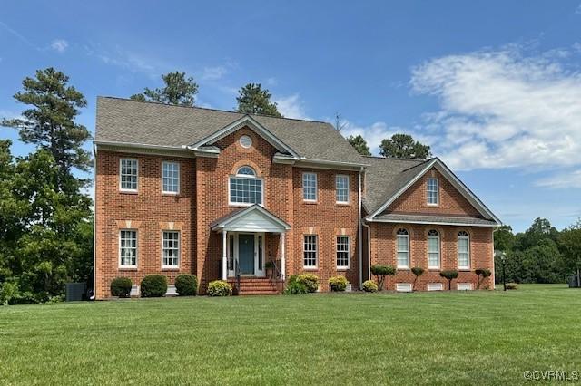 view of front of property featuring brick siding and a front yard