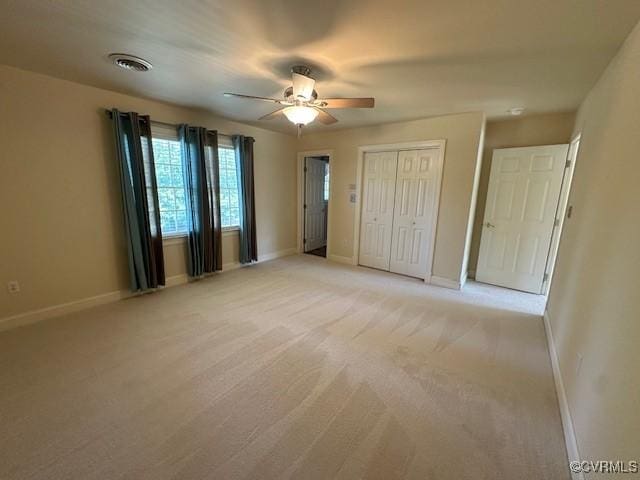 unfurnished bedroom featuring baseboards, a closet, visible vents, and light carpet