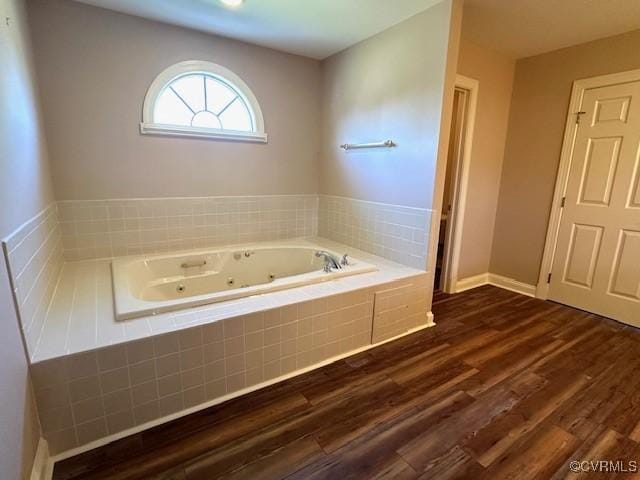 bathroom featuring a jetted tub and wood finished floors