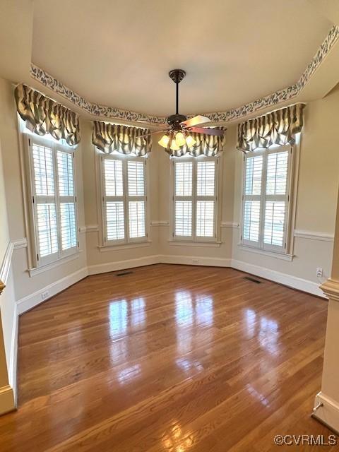 unfurnished dining area featuring visible vents, wood finished floors, and a wealth of natural light