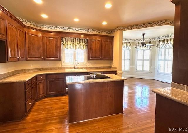 kitchen featuring light countertops, a sink, a notable chandelier, and a healthy amount of sunlight