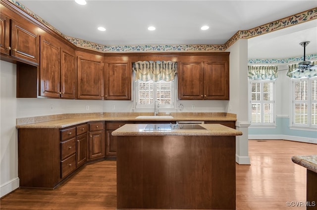 kitchen with baseboards, a sink, and wood finished floors