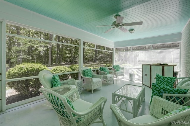sunroom with a ceiling fan and an outdoor living space