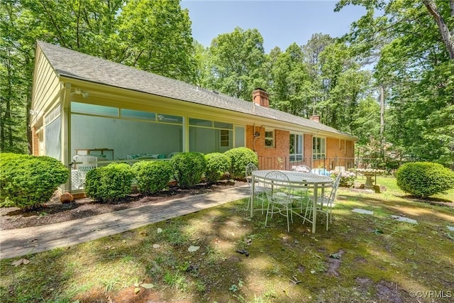 rear view of property featuring a chimney and outdoor dining area