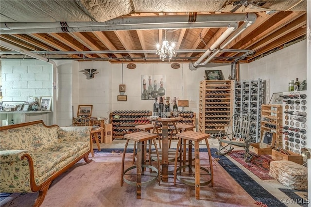 wine cellar with concrete floors, concrete block wall, and a chandelier