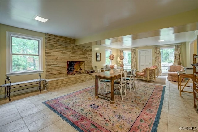 dining area with light tile patterned floors and a fireplace