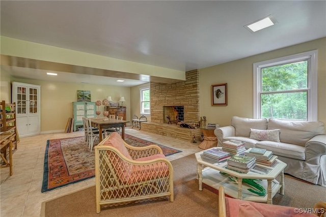 tiled living room with a stone fireplace