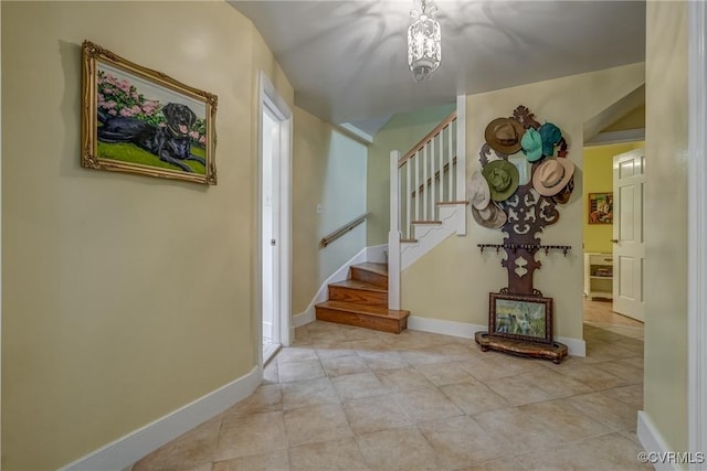 entryway featuring stairs, tile patterned flooring, baseboards, and a chandelier