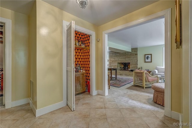 hallway featuring light tile patterned floors and baseboards