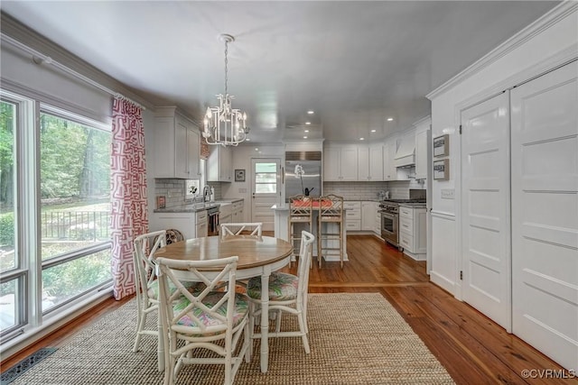 dining area with a chandelier, wood finished floors, and recessed lighting