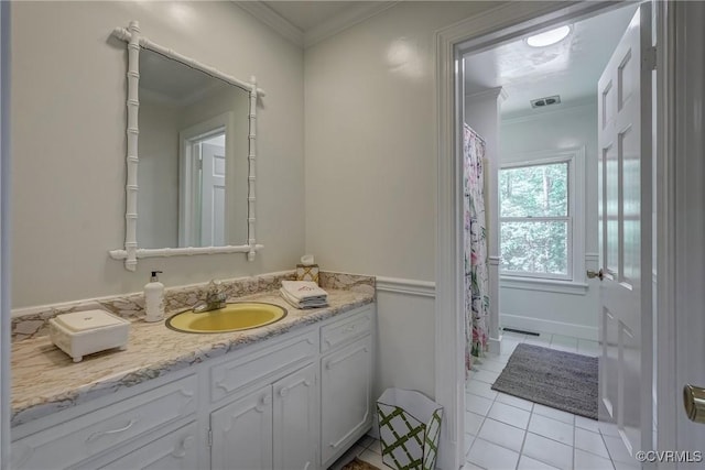 bathroom with tile patterned flooring, ornamental molding, and vanity
