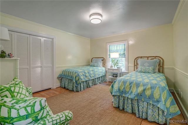 bedroom with crown molding, a closet, and wood finished floors