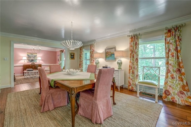 dining room featuring crown molding, a chandelier, light wood-style floors, and baseboards