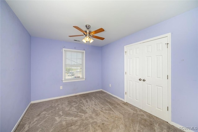 unfurnished bedroom with ceiling fan, carpet floors, baseboards, visible vents, and a closet
