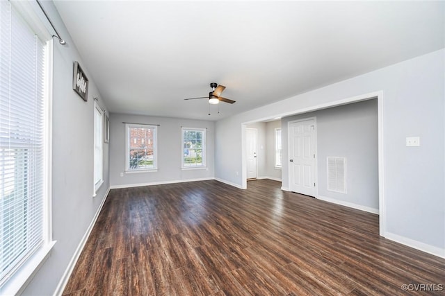 unfurnished living room featuring visible vents, a ceiling fan, baseboards, and dark wood-type flooring