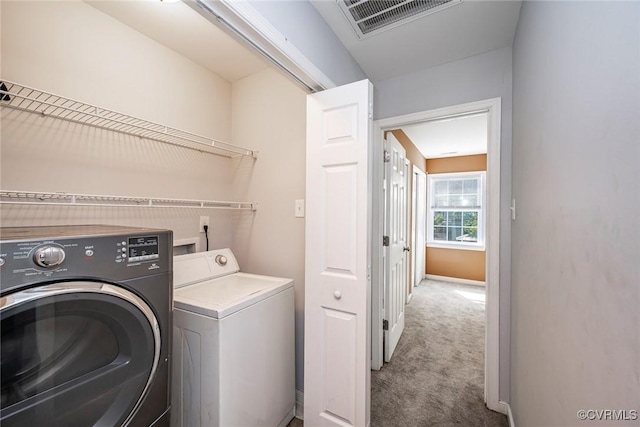 clothes washing area with laundry area, visible vents, baseboards, carpet flooring, and washer and dryer