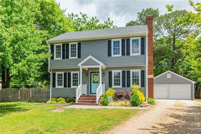 colonial house featuring fence, an outdoor structure, a garage, a front yard, and a chimney