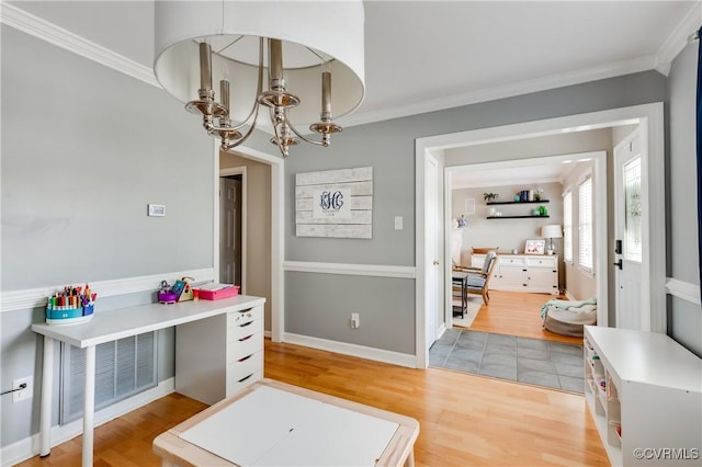 dining area with an inviting chandelier, crown molding, and light wood-style floors