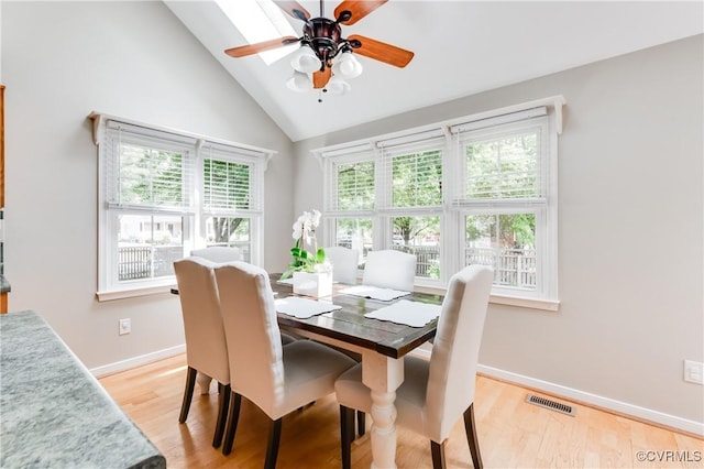 dining space featuring baseboards, ceiling fan, visible vents, high vaulted ceiling, and light wood-type flooring