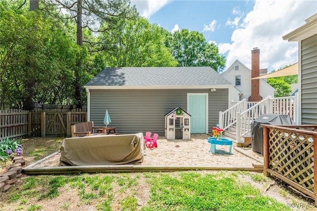 back of house with roof with shingles and fence