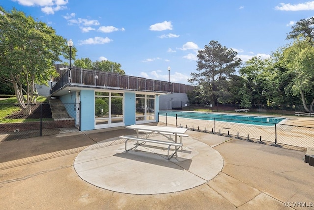 community pool featuring fence and a patio