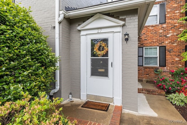 entrance to property featuring brick siding