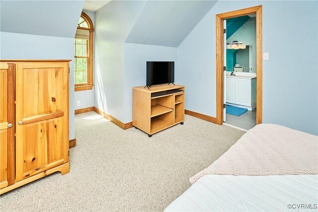 bedroom featuring baseboards, light carpet, and vaulted ceiling
