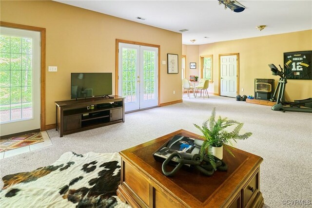 living room with baseboards, visible vents, light carpet, and french doors