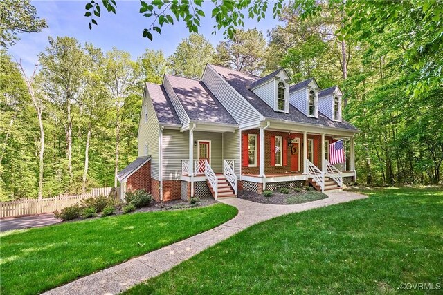cape cod home featuring fence, covered porch, roof with shingles, and a front yard