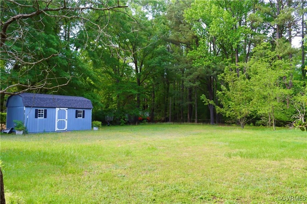 view of yard featuring a storage unit and an outbuilding